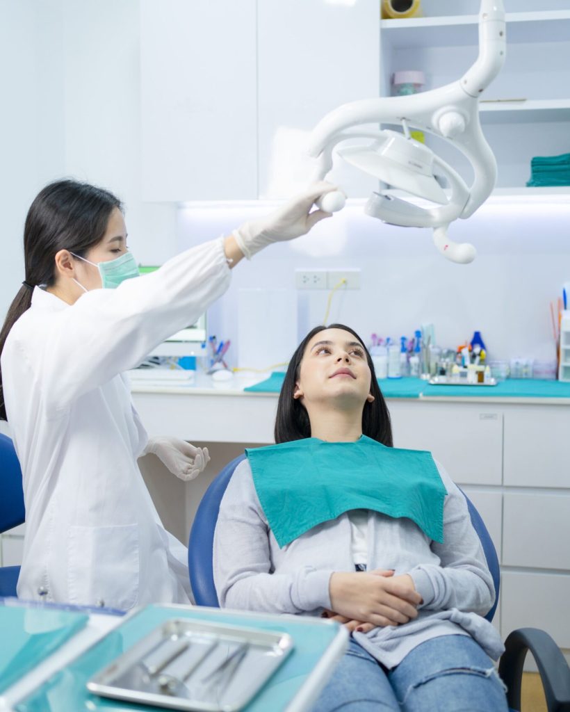 asian-female-dentist-adjust-dental-surgical-light-2021-12-09-07-32-46-utc-min